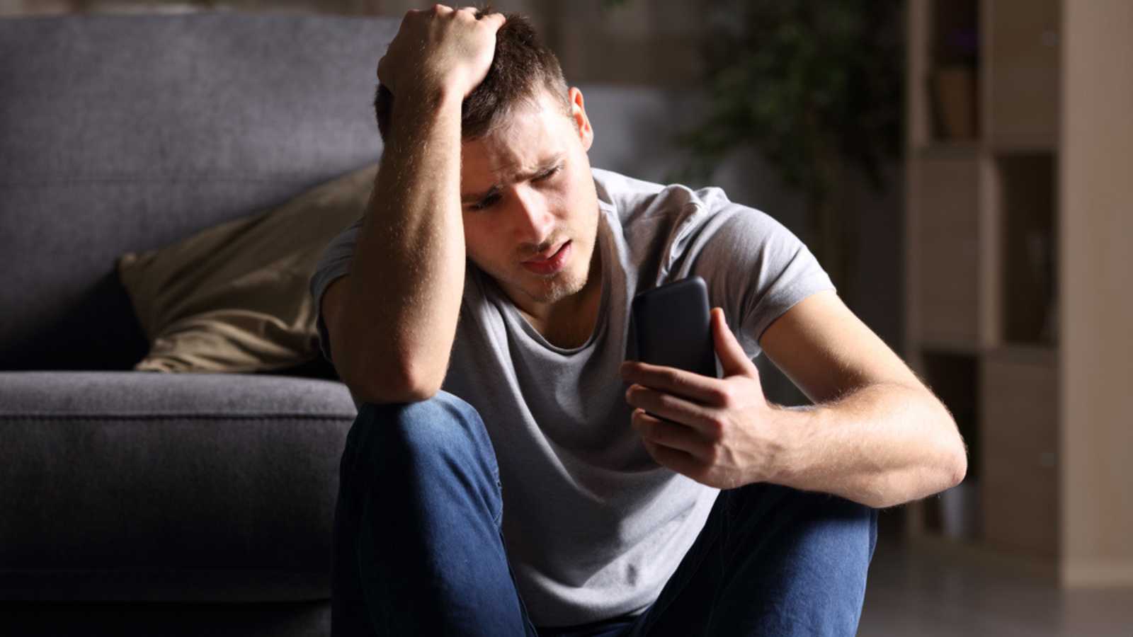 Man seeing mobile with hands on head