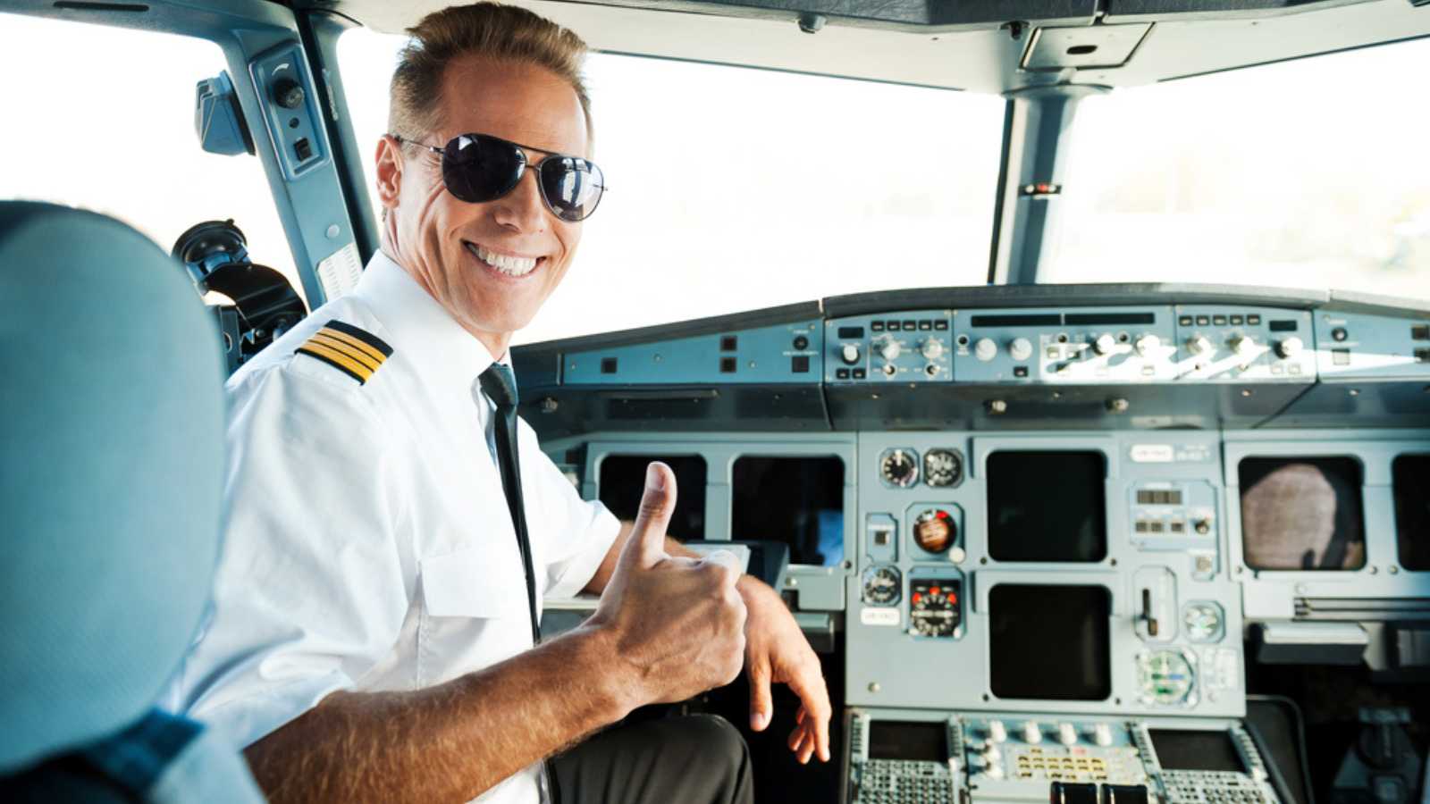 Ready to flight. Rear view of confident male pilot showing his thumb up and smiling while sitting in cockpit