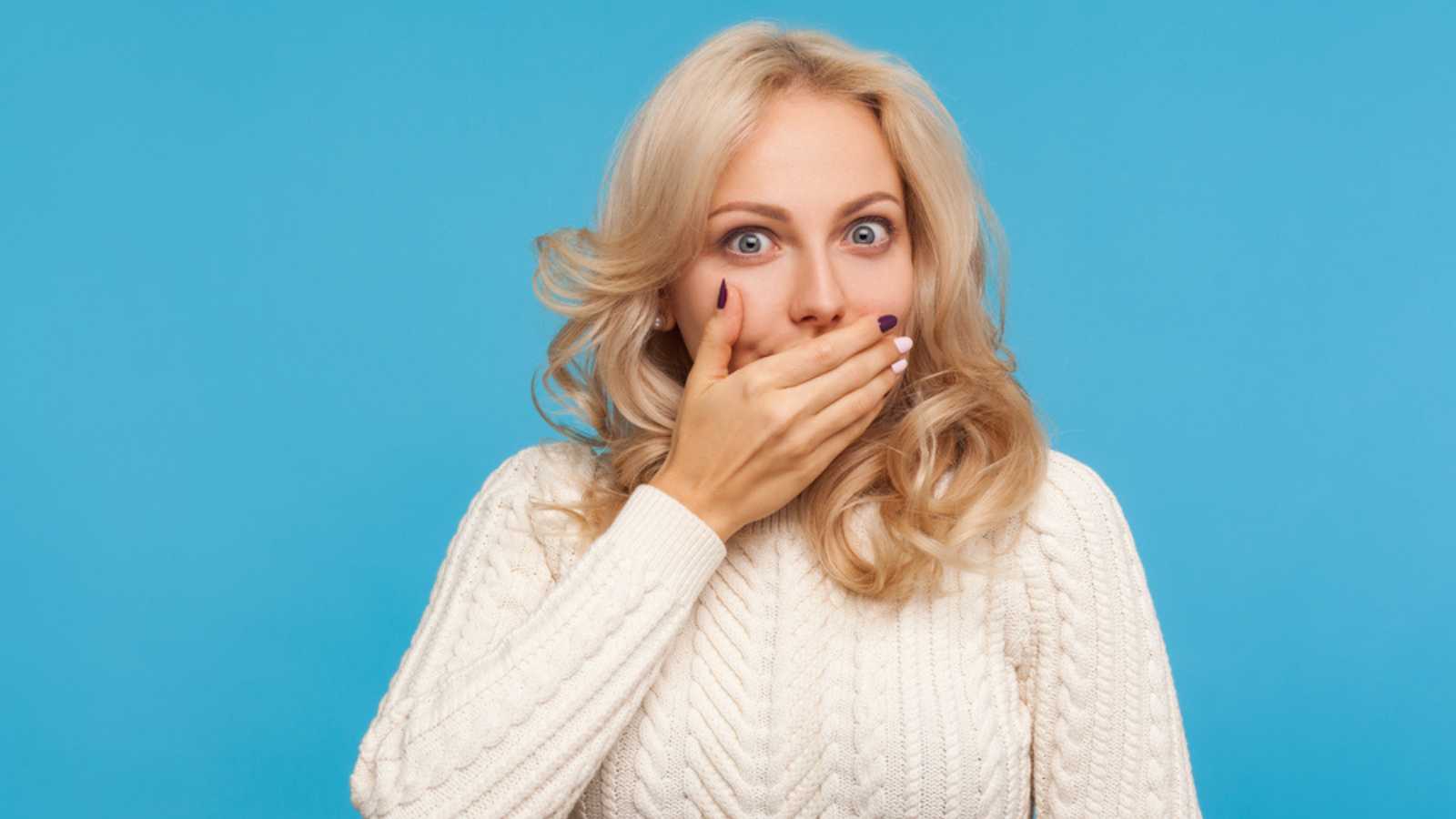 Woman shocked with hands over mouth