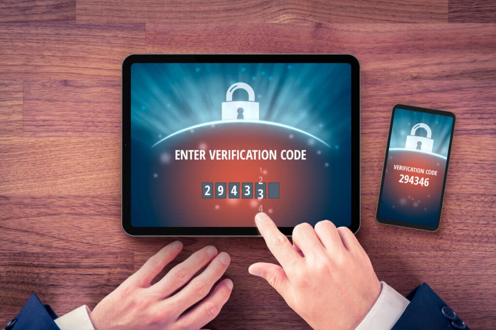 Two-factor authentication (2FA) and verification security concept. User with digital tablet and smart phone and two-factor authentication security process. Verify code on smart phone, flatlay design.